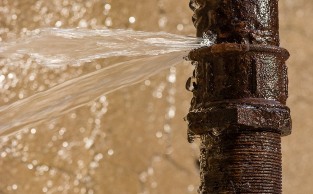 Plumber repairing a leaking water line repair with professional tools
